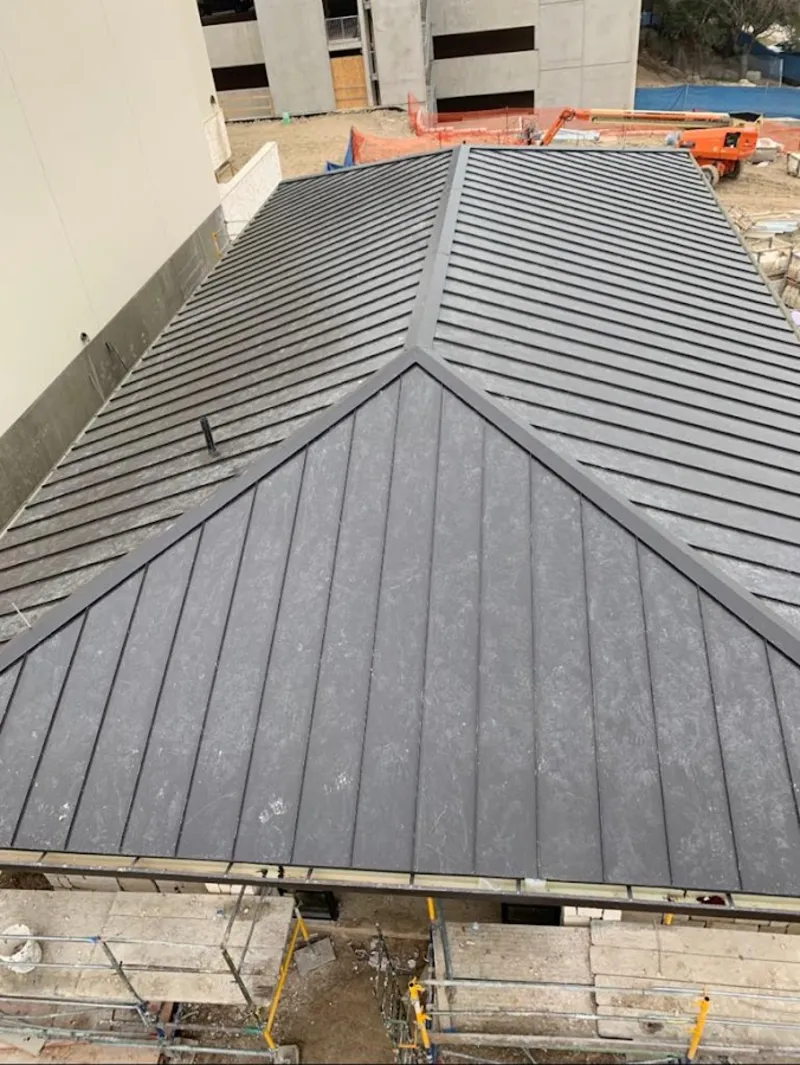 Commercial metal roof construction with crane equipment in Wheaton